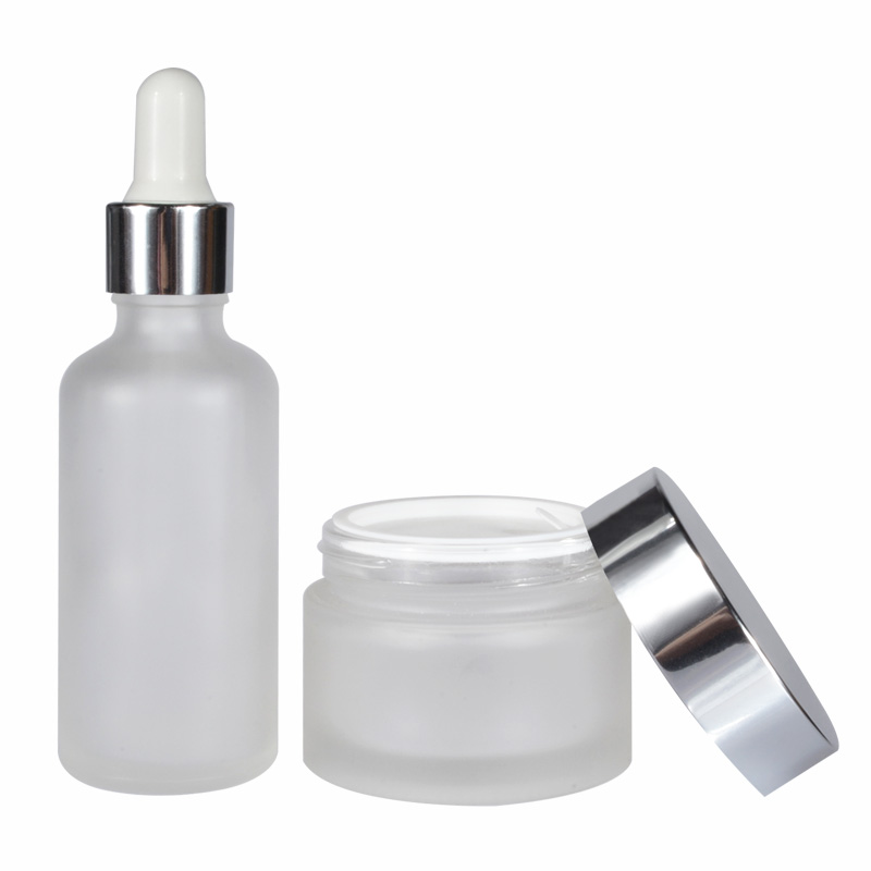 A set of frosted clear amber black personal skin care glass dropper bottles and glass jar