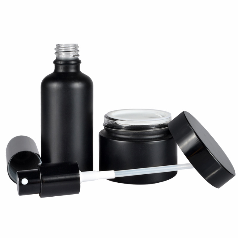 A set of frosted clear amber black personal skin care glass dropper bottles and glass jar