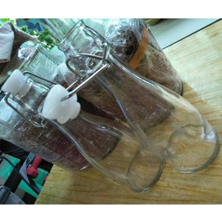 Best Selling 1000ml Clear Swing Top Embossed Round Glass Beverage Bottle for sales
