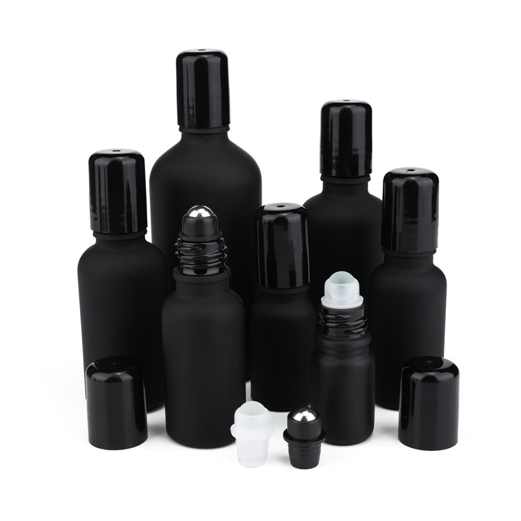 Black frosted glass roll on bottle with metal roller filling essential oil