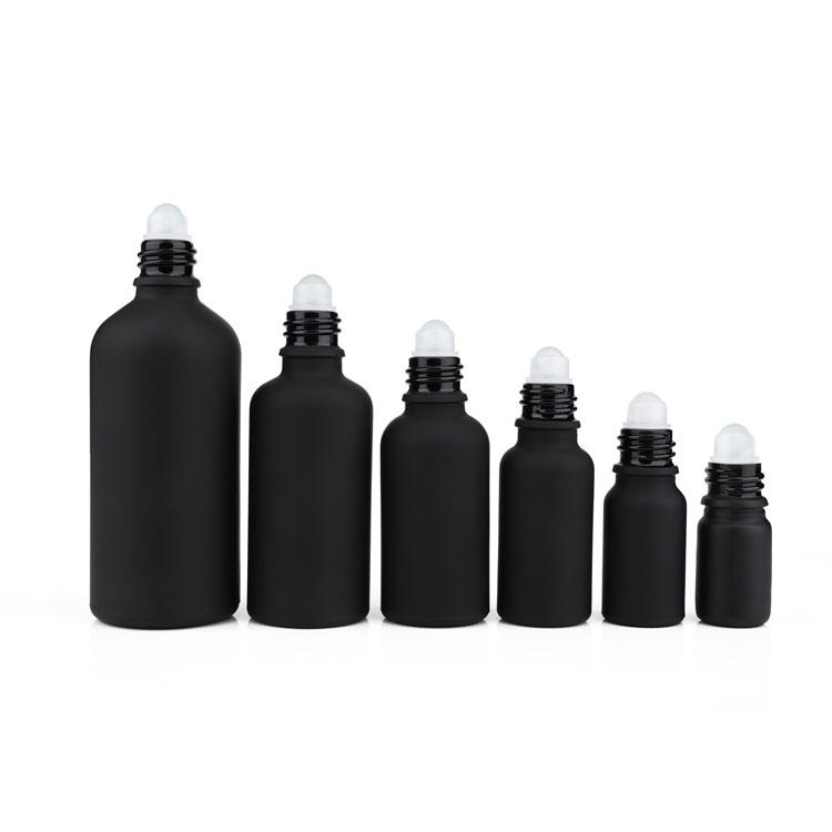 Black frosted glass roll on bottle with metal roller filling essential oil