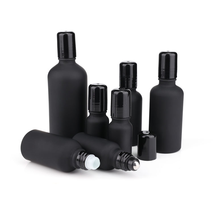 Black frosted glass roll on bottle with metal roller filling essential oil