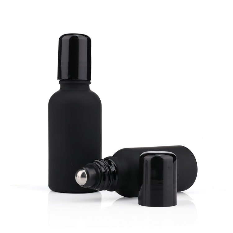 Black frosted glass roll on bottle with metal roller filling essential oil