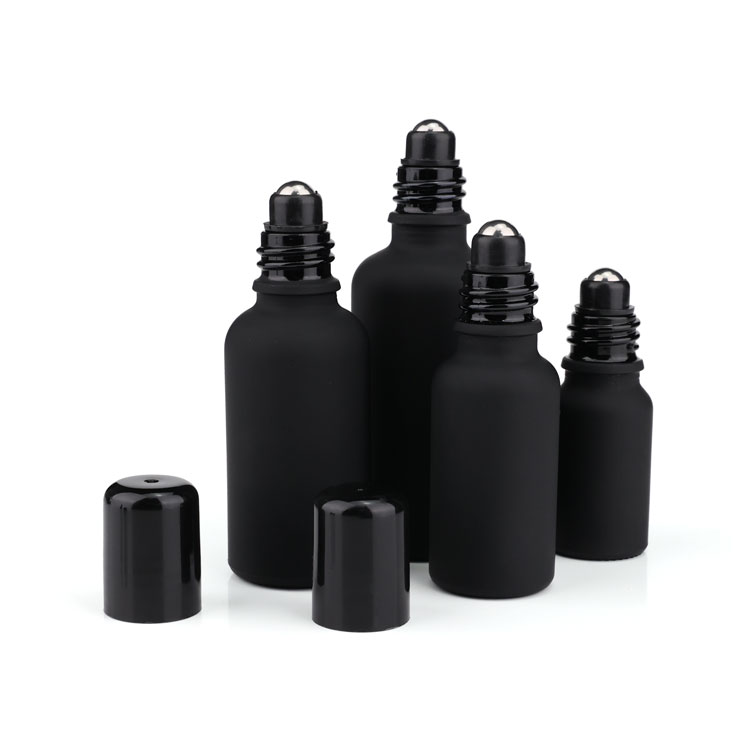 Black frosted glass roll on bottle with metal roller filling essential oil
