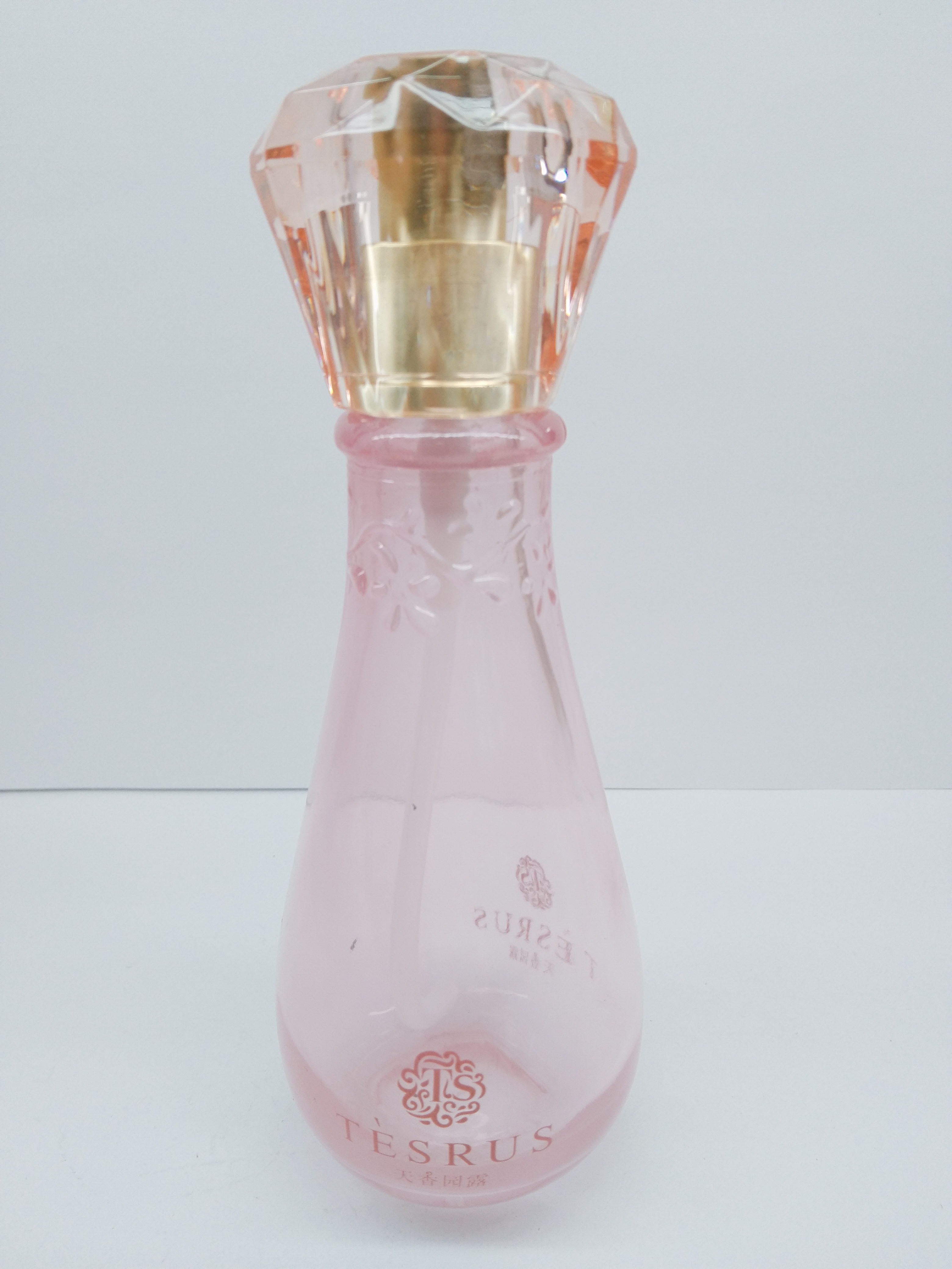 Clear pink color glass bottle with diamond-shaped cap
