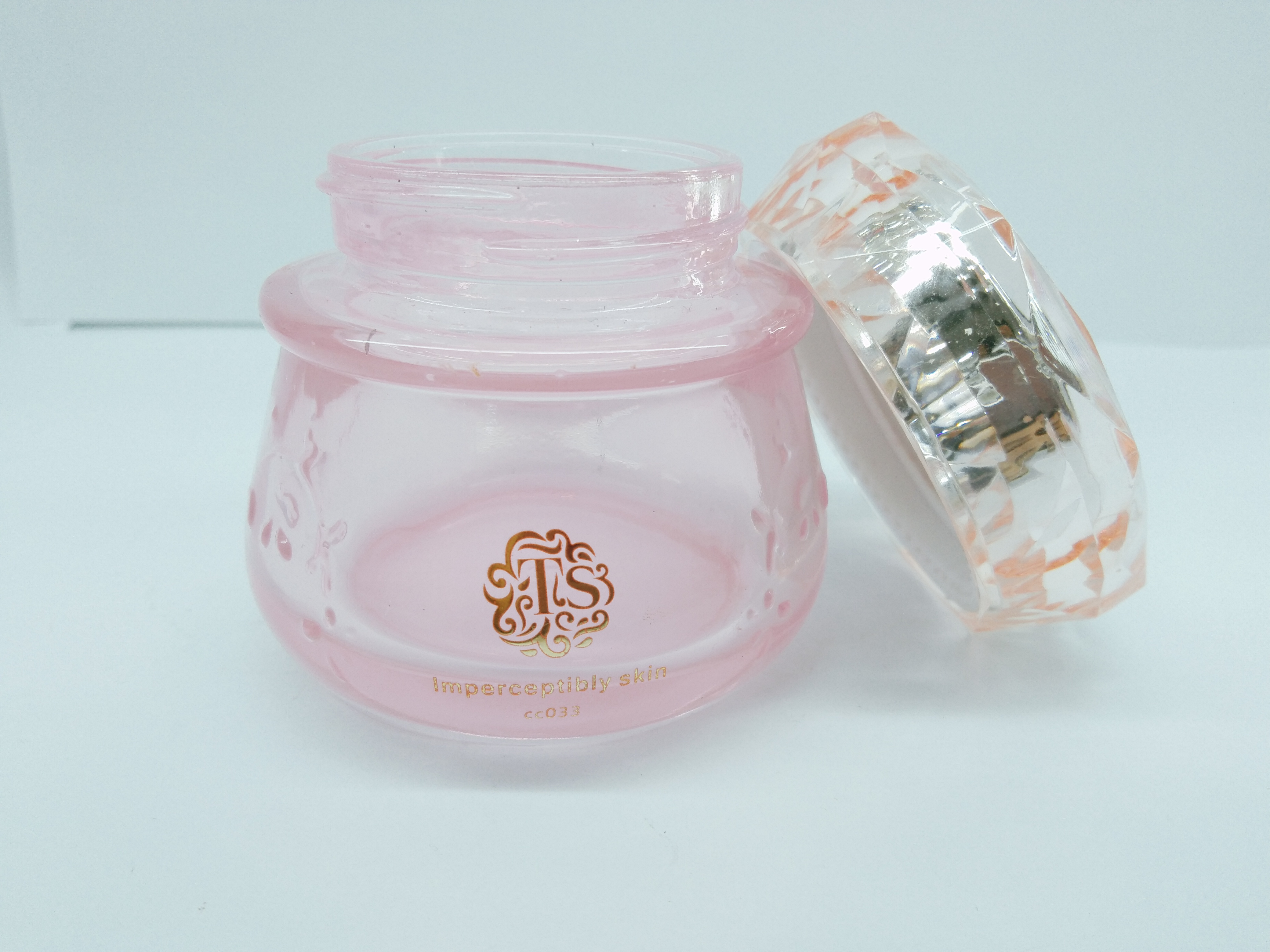 Clear pink color glass bottle with diamond-shaped cap