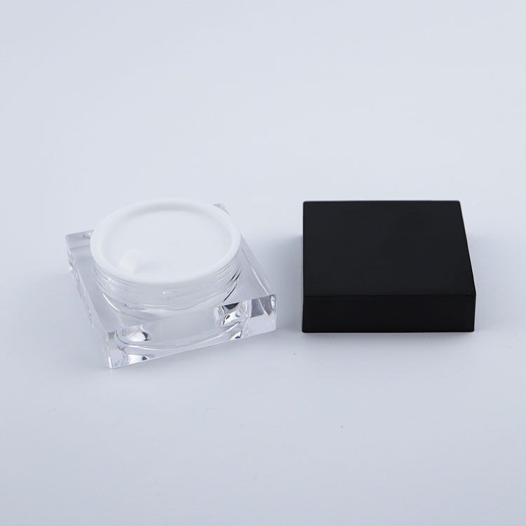 Clear plastic square cream jar with black lid