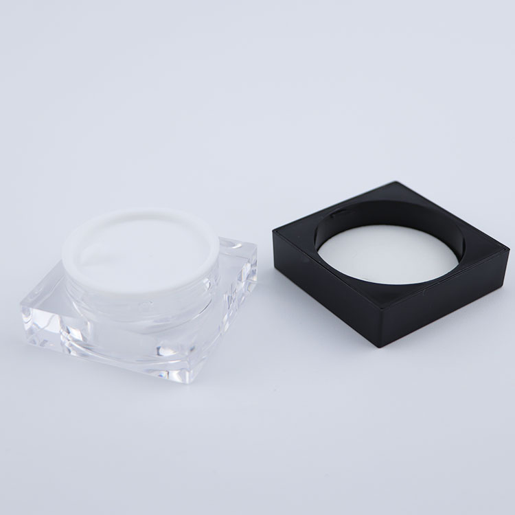 Clear plastic square cream jar with black lid