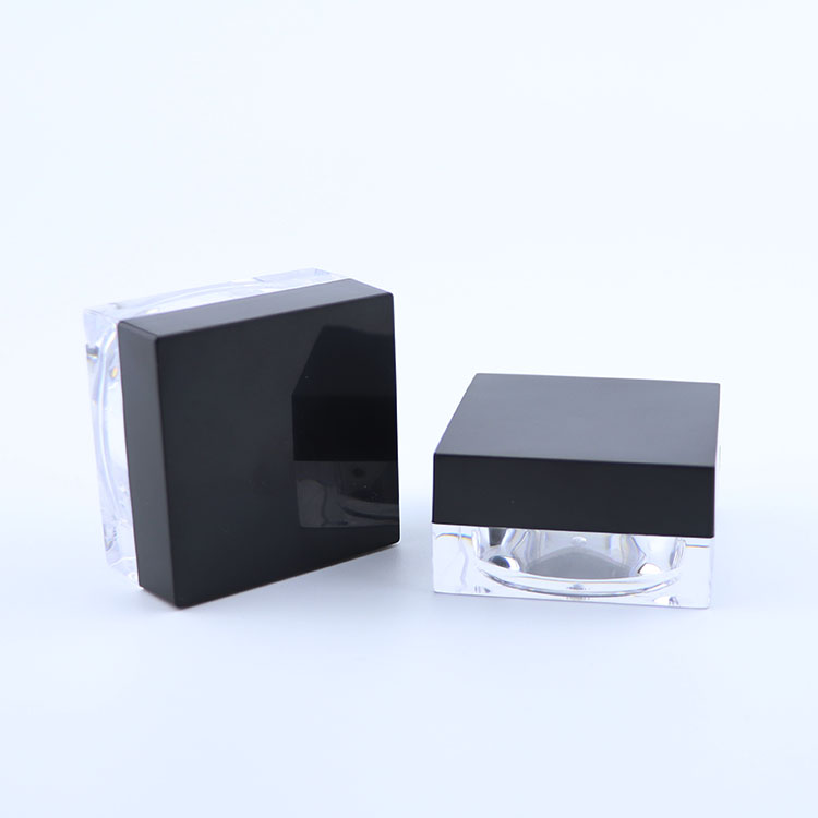 Clear plastic square cream jar with black lid