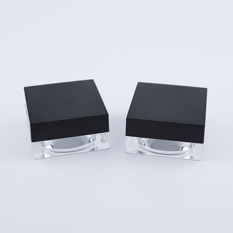 Clear plastic square cream jar with black lid