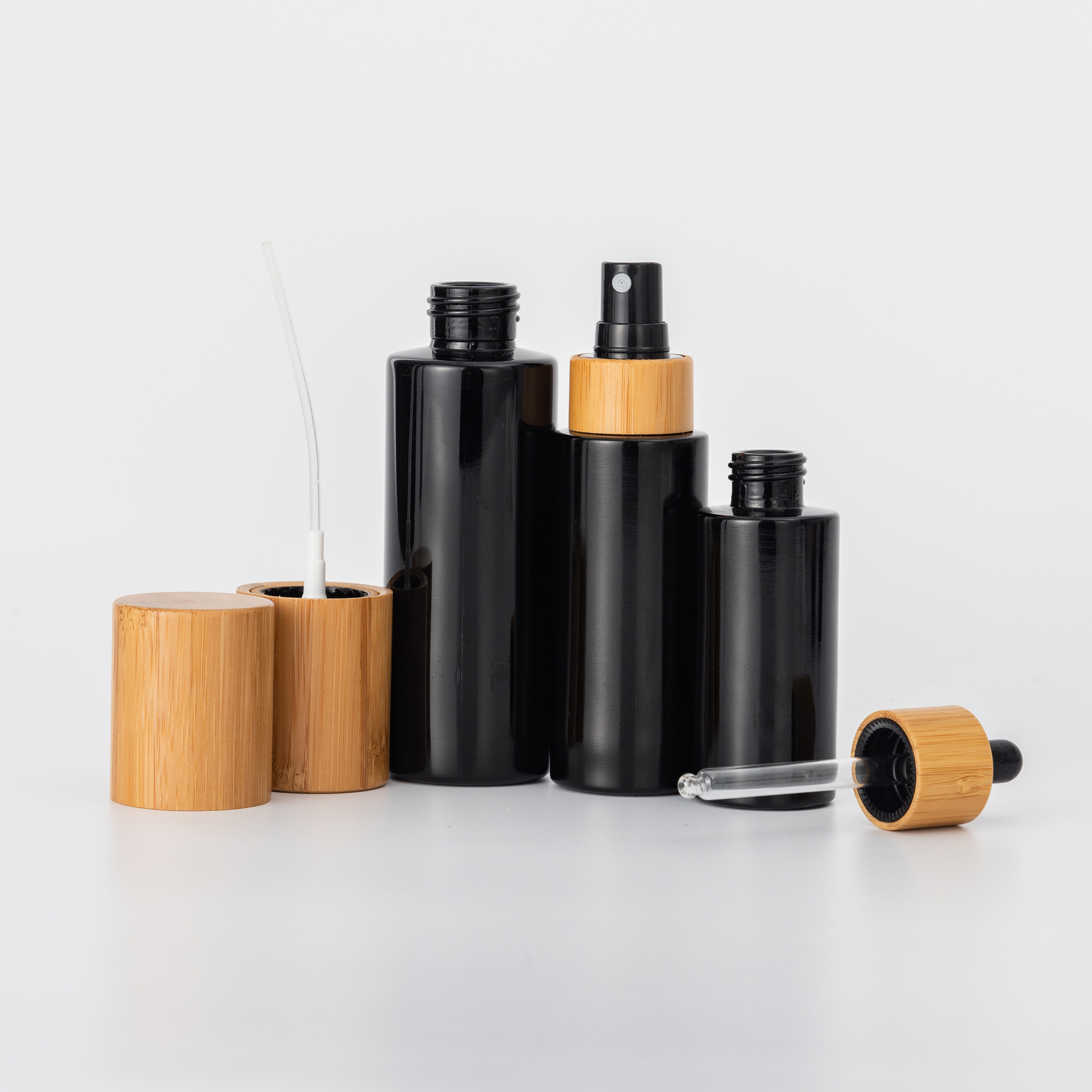 Cosmetic black glass pump bottles and cream jars with bamboo lid
