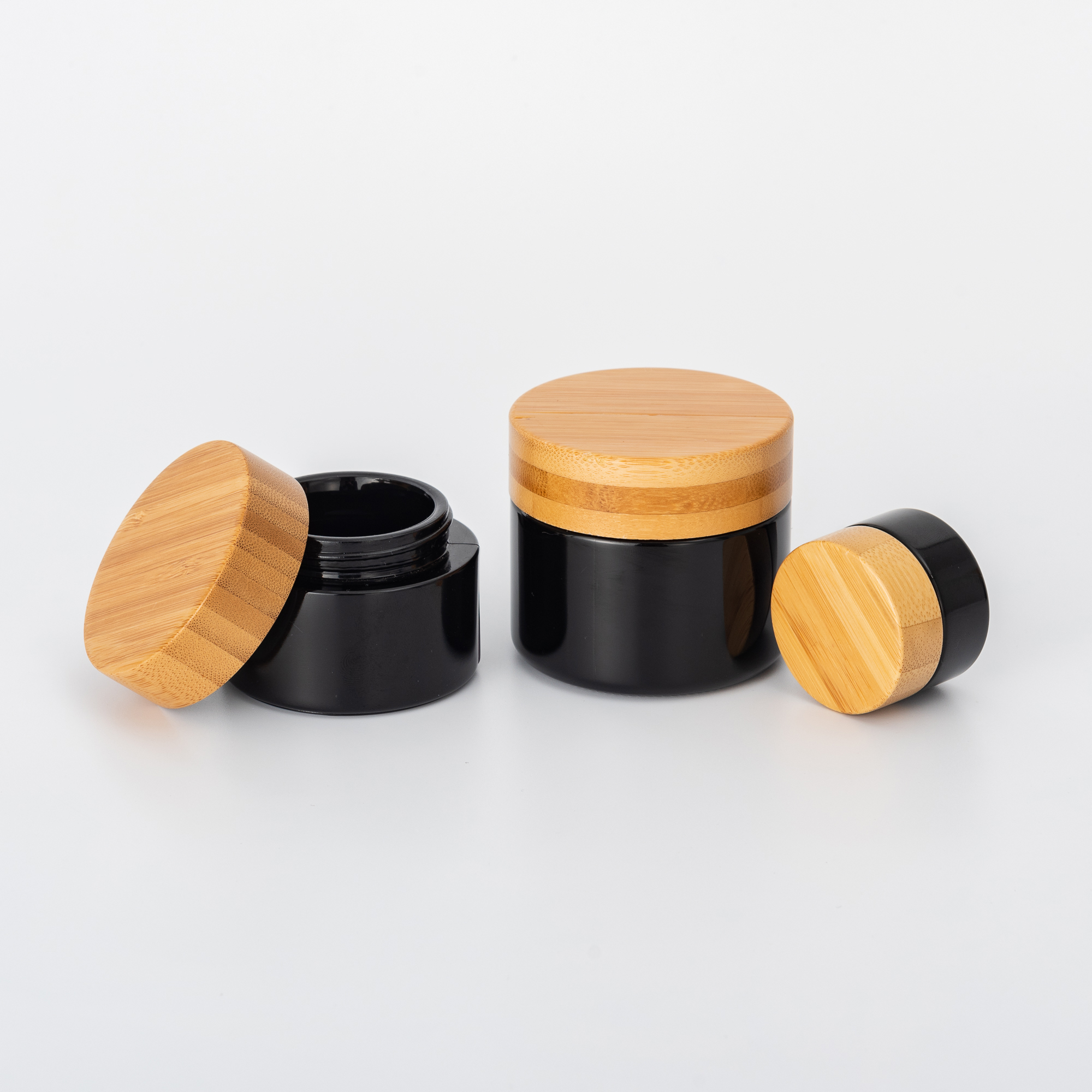 Cosmetic black glass pump bottles and cream jars with bamboo lid