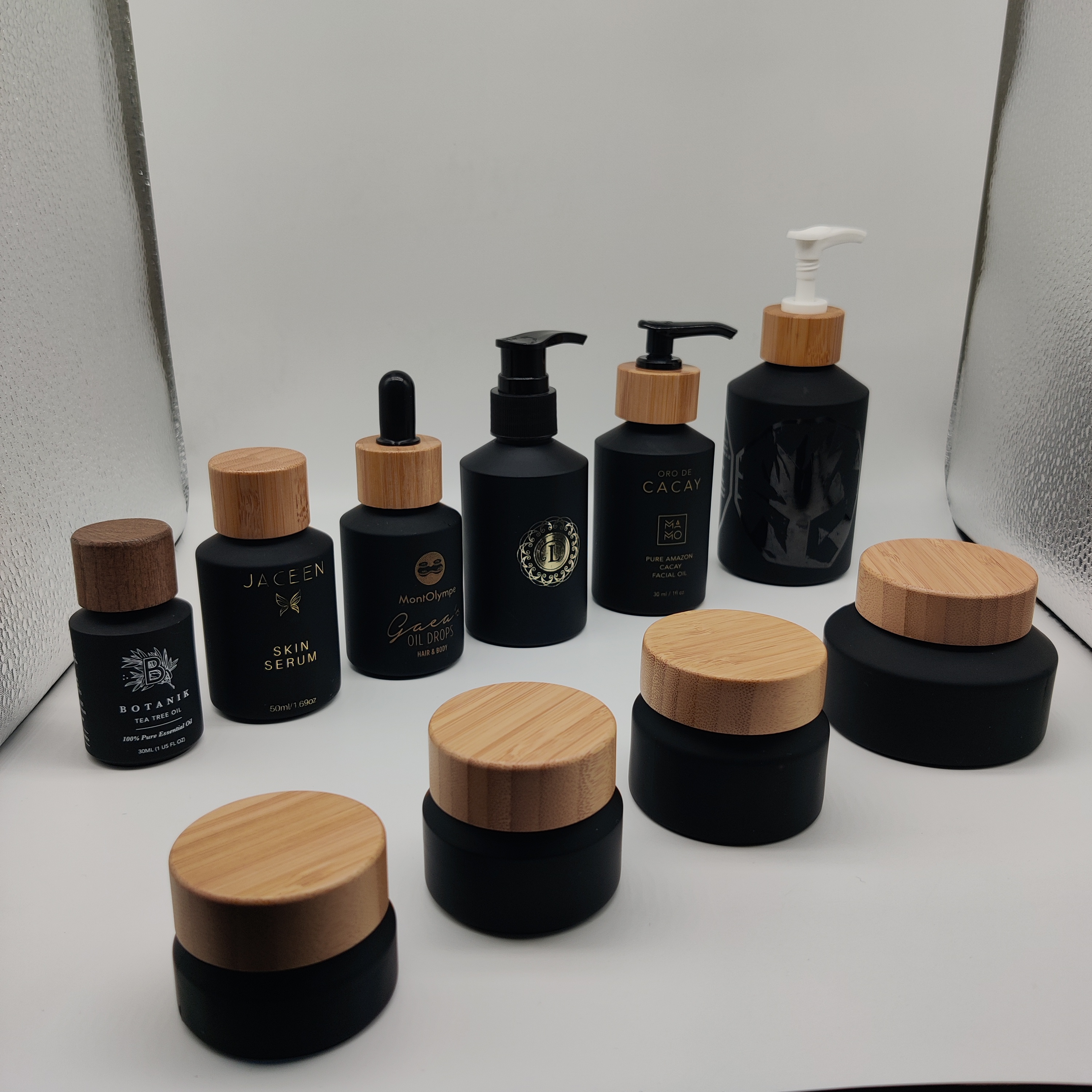 Cosmetic packaging slant shoulder matte black skin care set glass bottle cosmetic products with black dropper and jar with lid