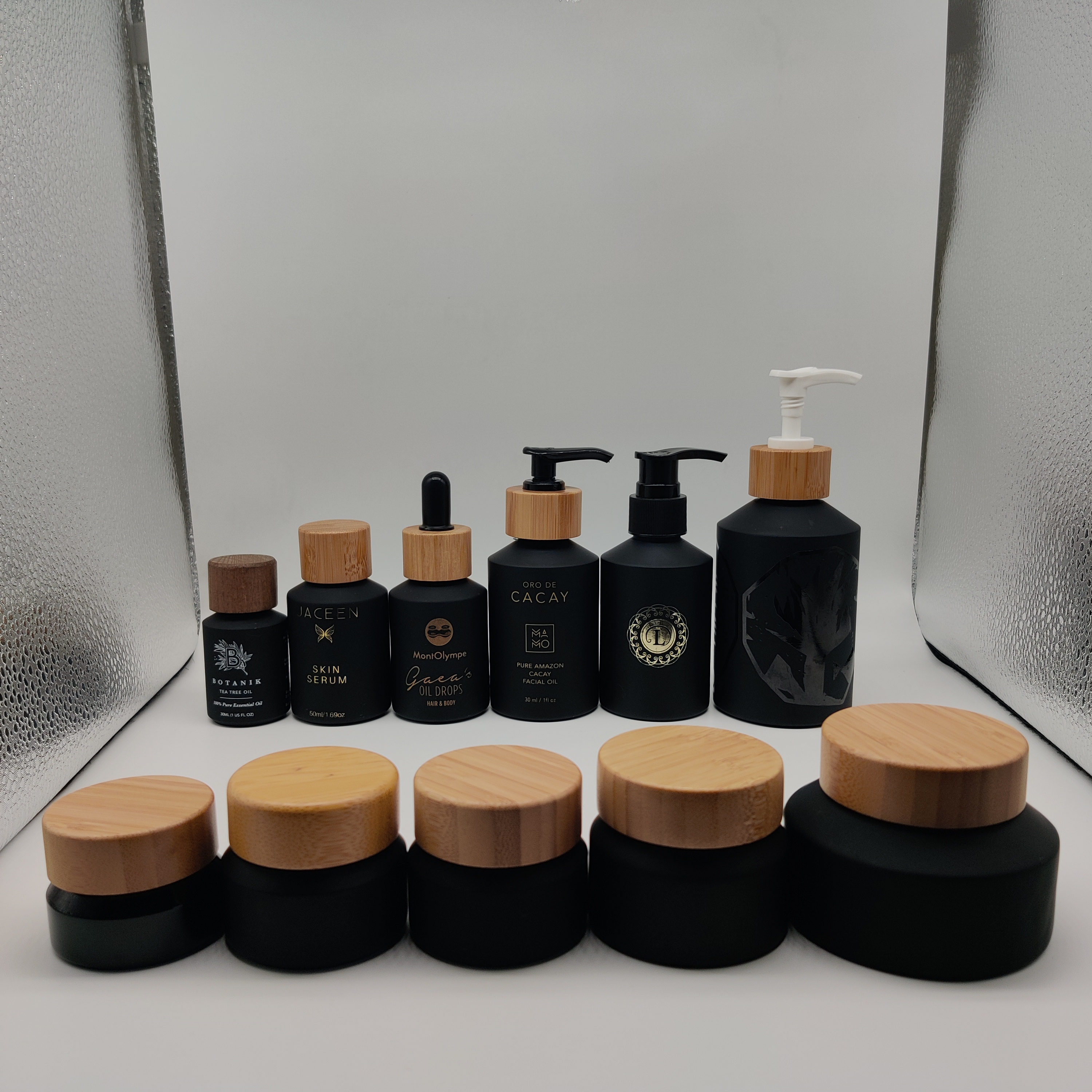 Cosmetic packaging slant shoulder matte black skin care set glass bottle cosmetic products with black dropper and jar with lid