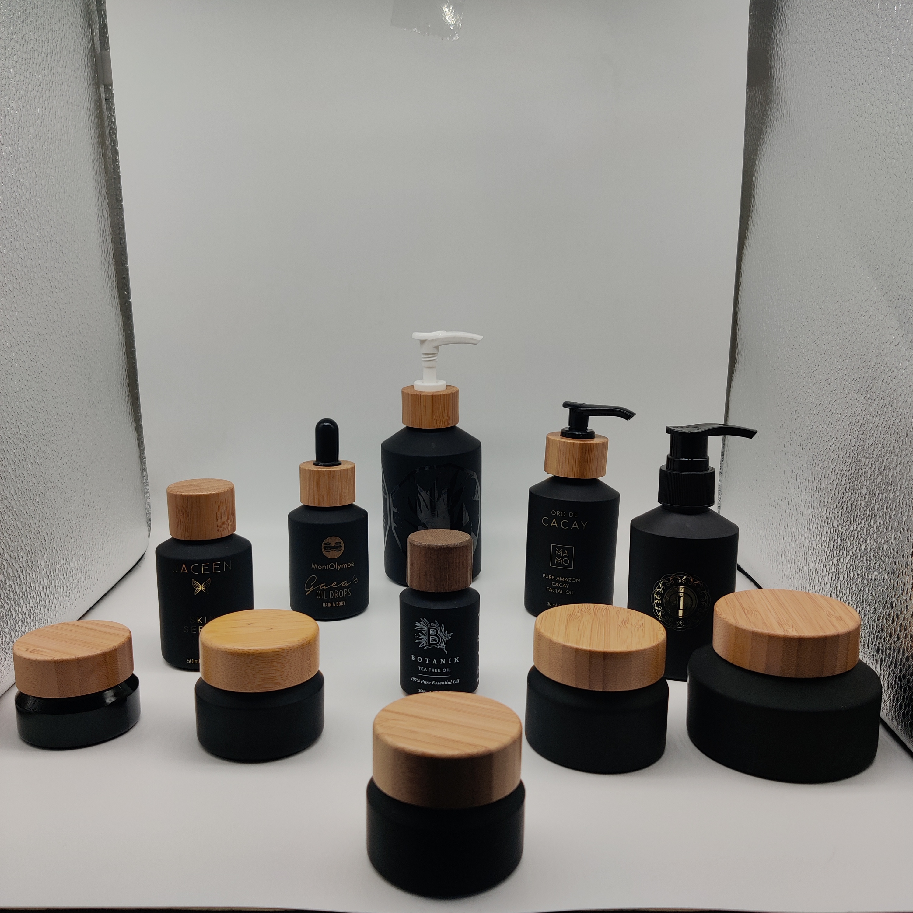Cosmetic packaging slant shoulder matte black skin care set glass bottle cosmetic products with black dropper and jar with lid