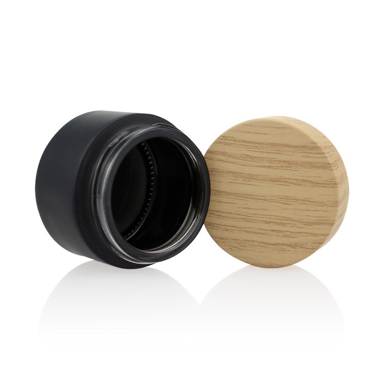 Custom logo small package 10g 15g 20g 30g 50g 60g black glass jar with wood grain cap for cosmetic facial essence cream