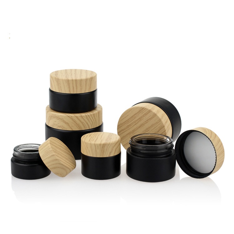 Custom logo small package 10g 15g 20g 30g 50g 60g black glass jar with wood grain cap for cosmetic facial essence cream