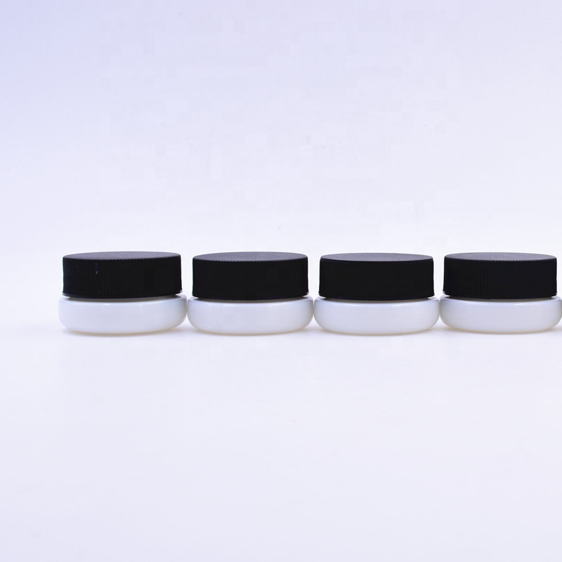 Cute 3 ml white round small straight side eye cream cosmetic packing glass jar with black plastic child proof lid.