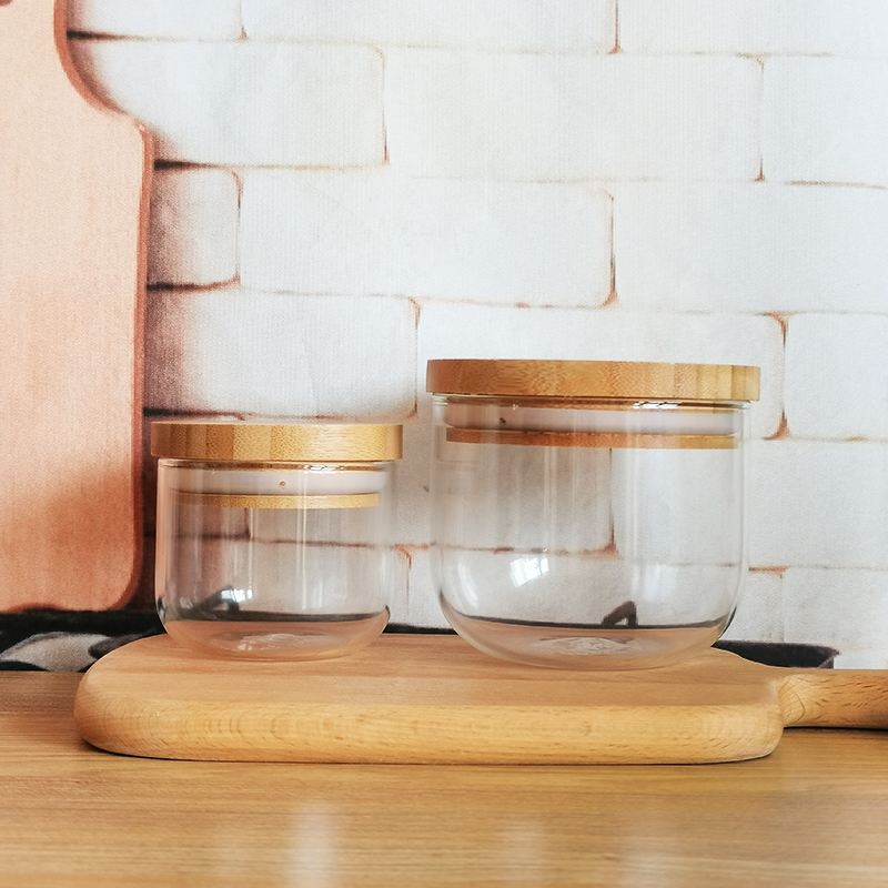 Delicate round bottom small glass jar with bamboo cover