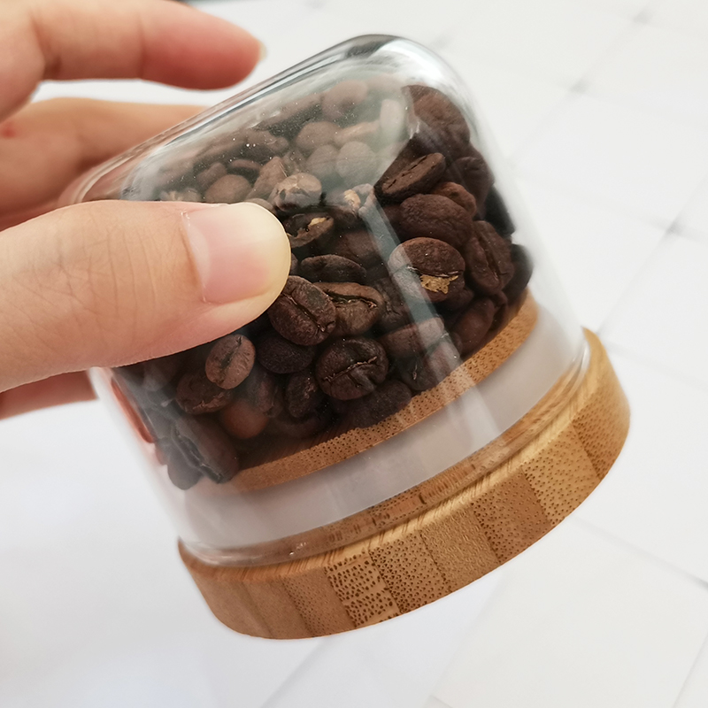 Delicate round bottom small glass jar with bamboo cover