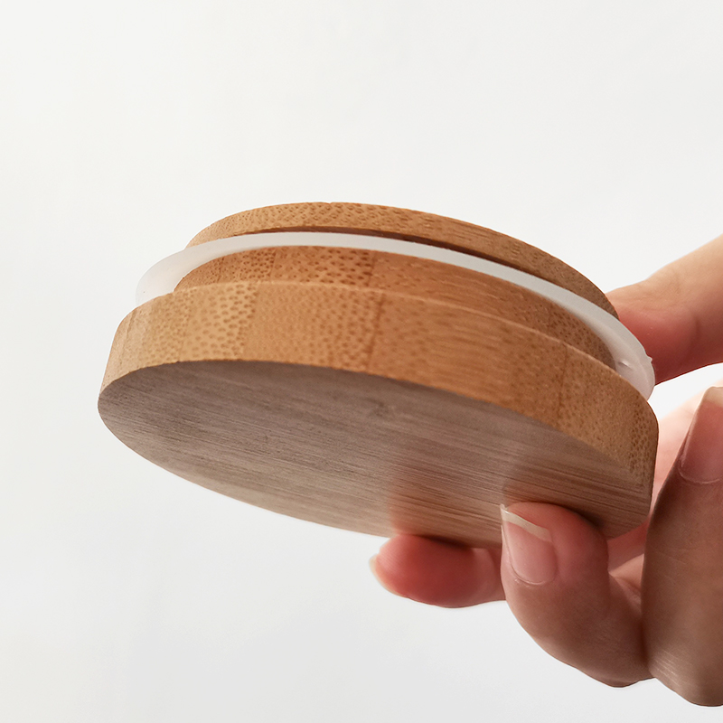 Delicate round bottom small glass jar with bamboo cover
