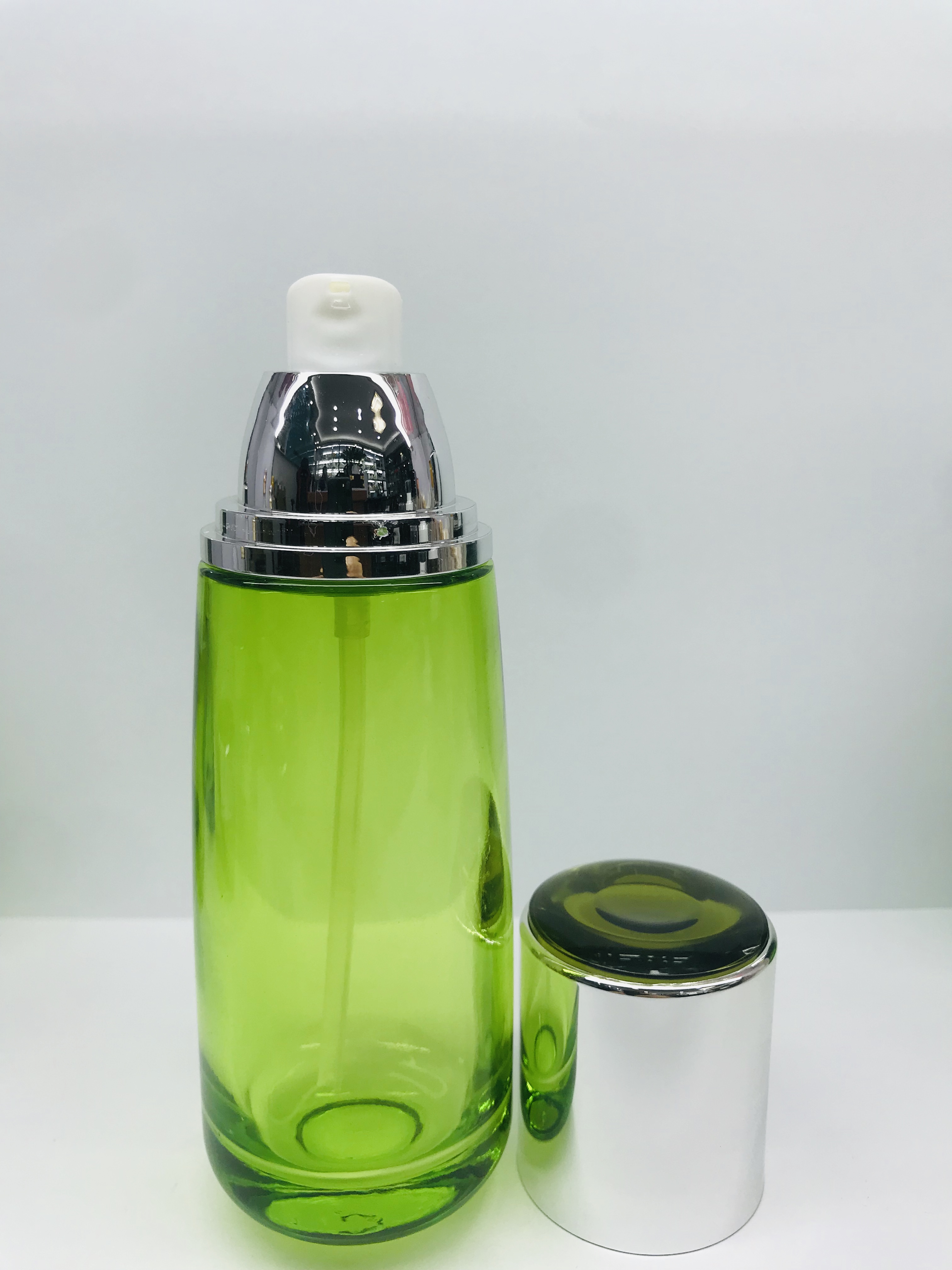 Emerald green round cream glass bottle