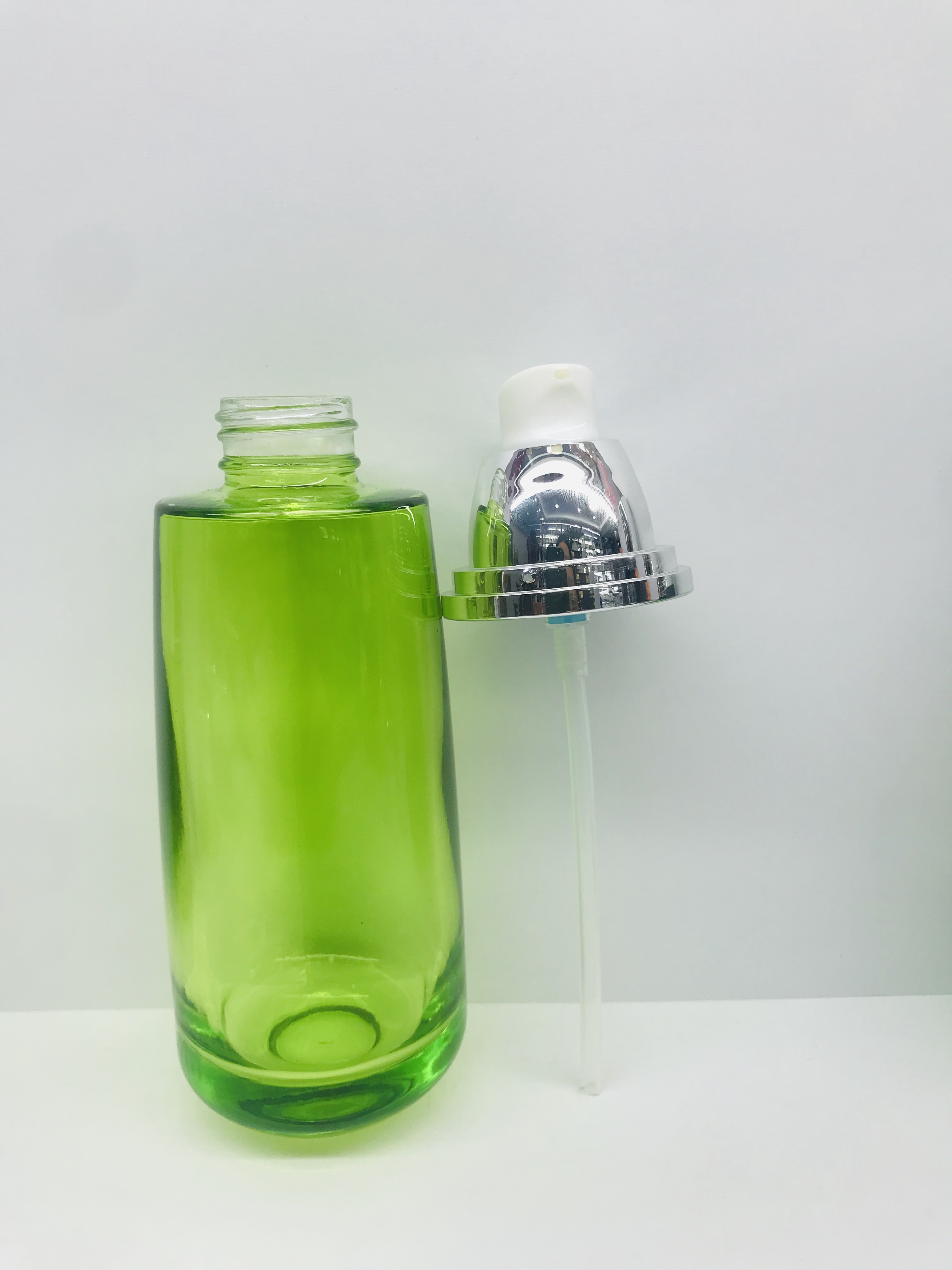 Emerald green round cream glass bottle