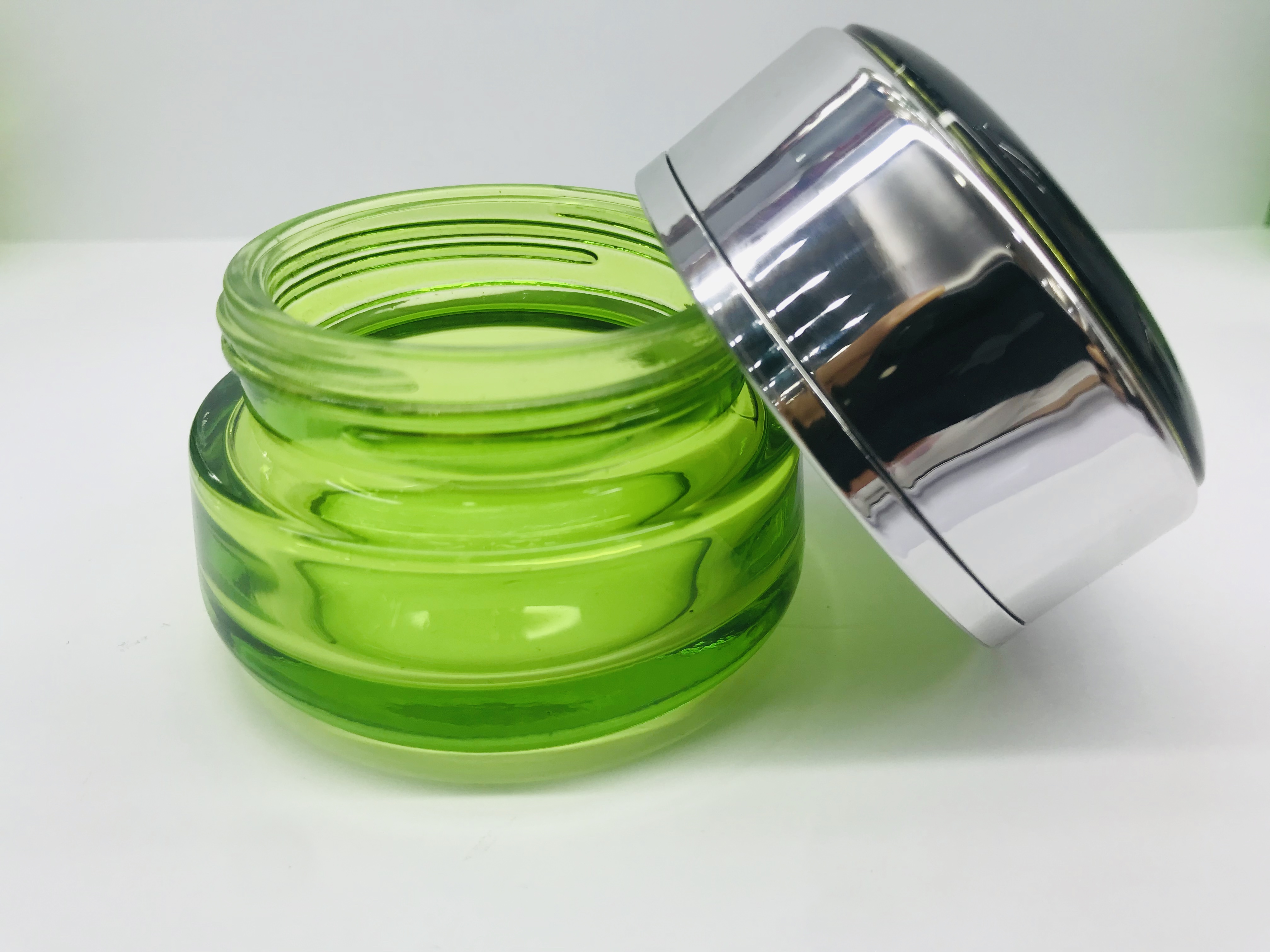 Emerald green round cream glass bottle