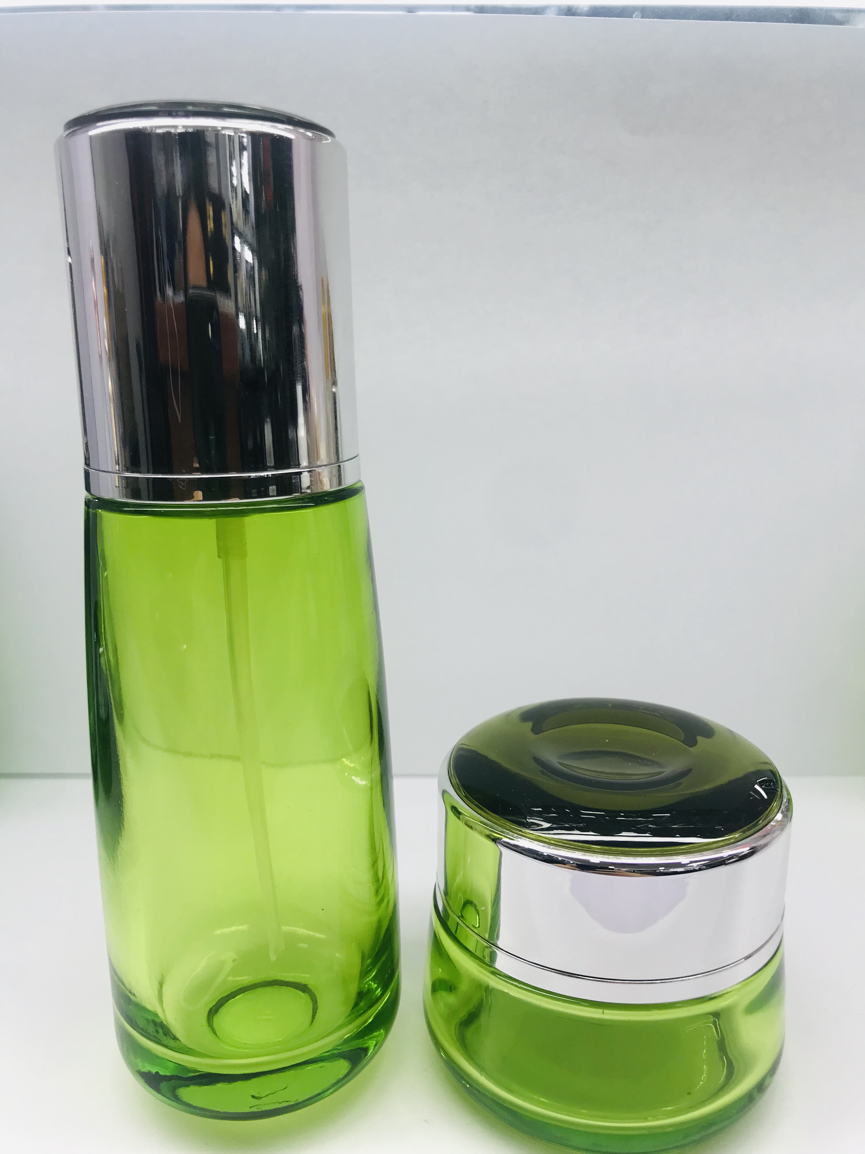 Emerald green round cream glass bottle