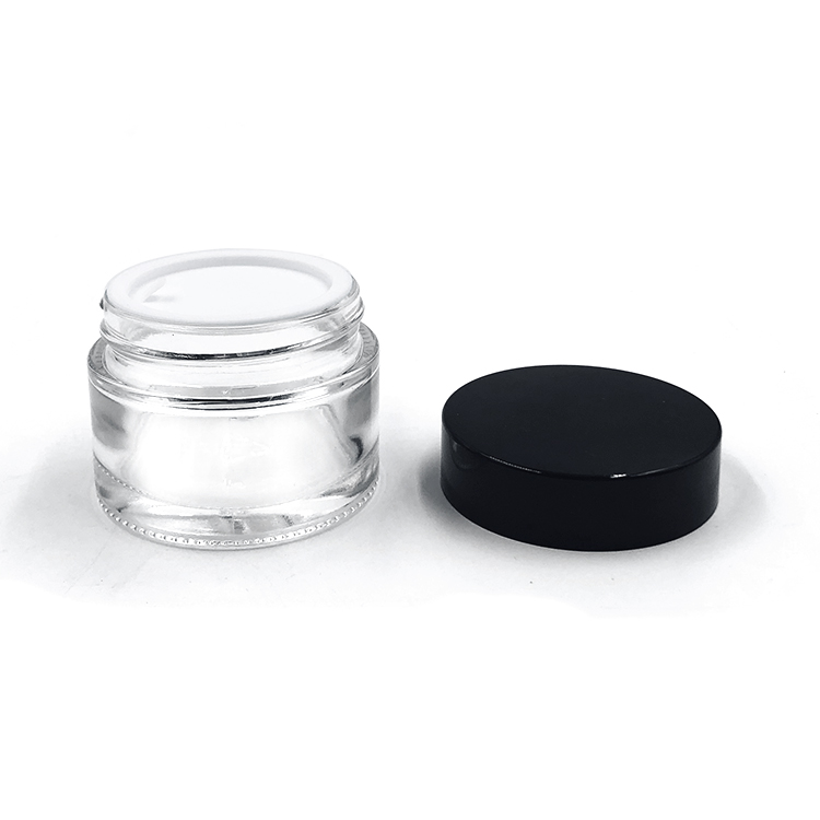 Empty round 2oz glass cosmetic jar with plastic lid