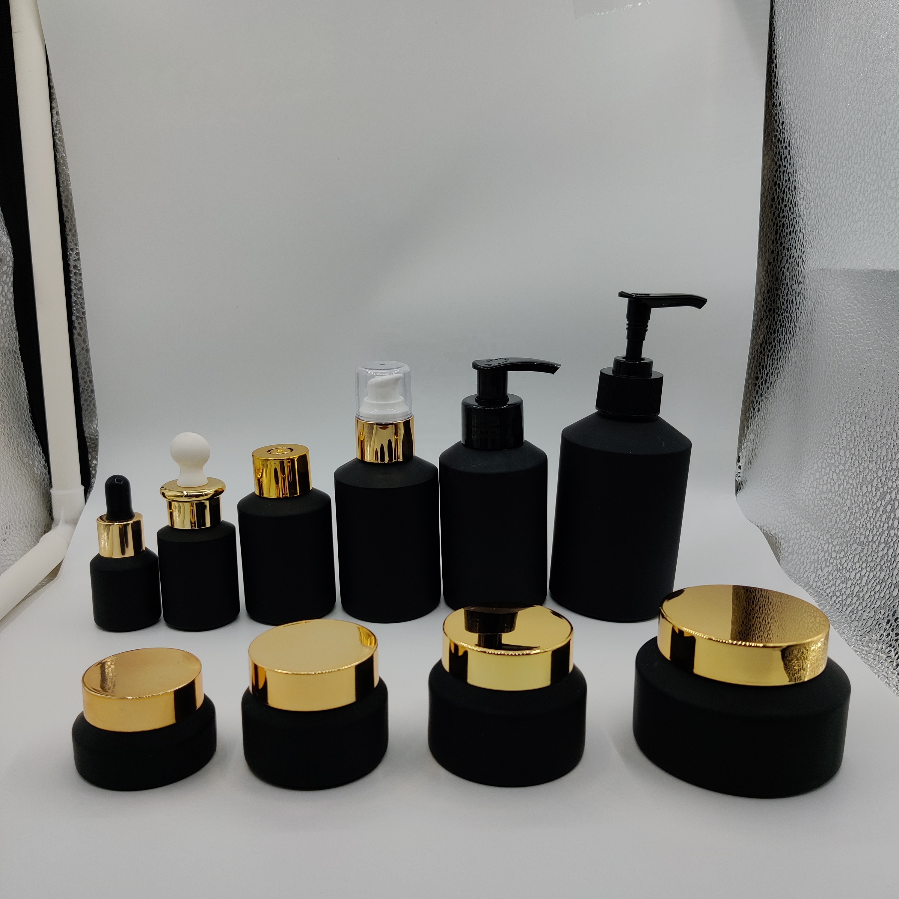 Factory hot sale cosmetic bottle jar packaging series frosted black slant shoulder glass lotion bottle with gold lid