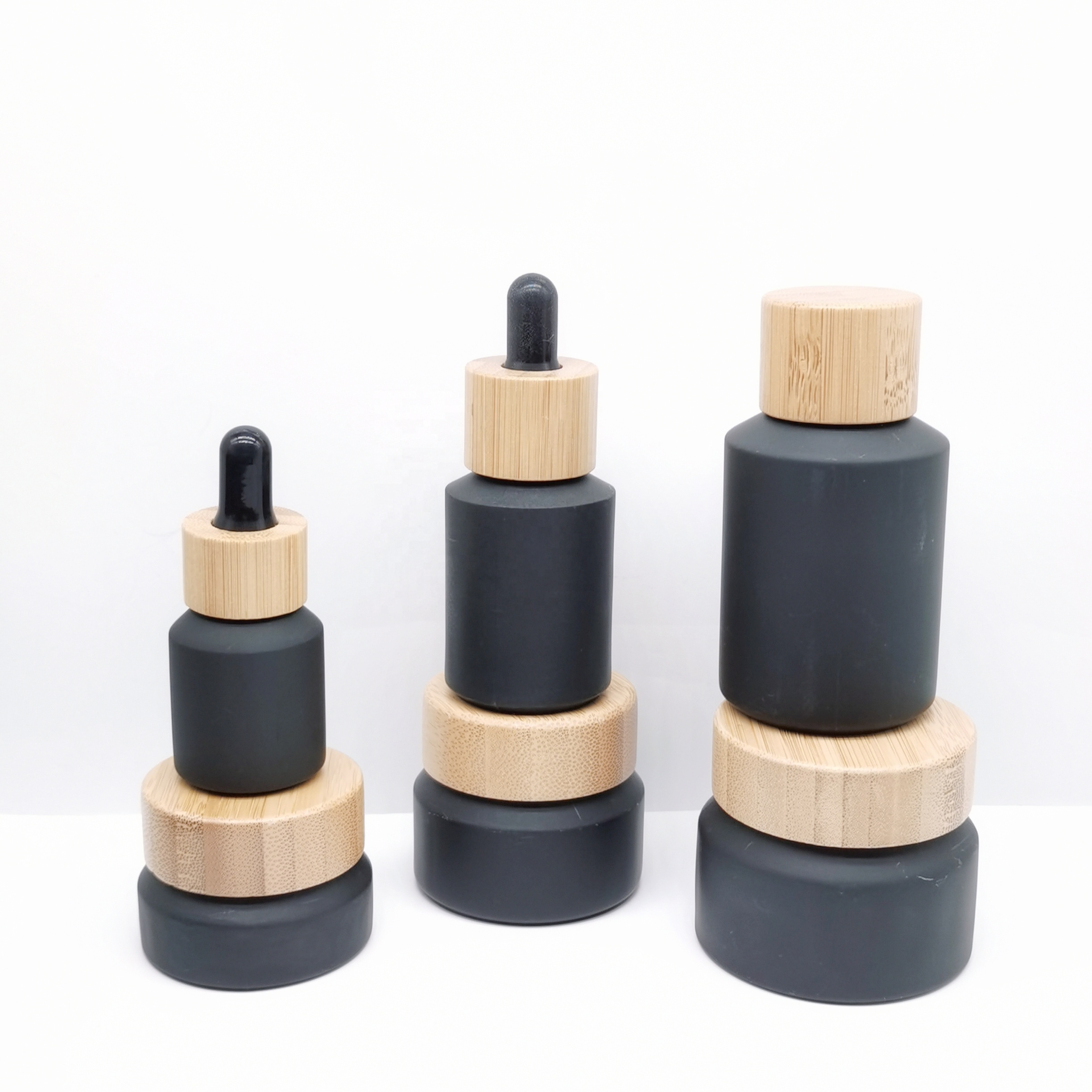 Factory production cosmetic glass bottles packaging slant shoulder matte black glass bottle and jar with bamboo lid series