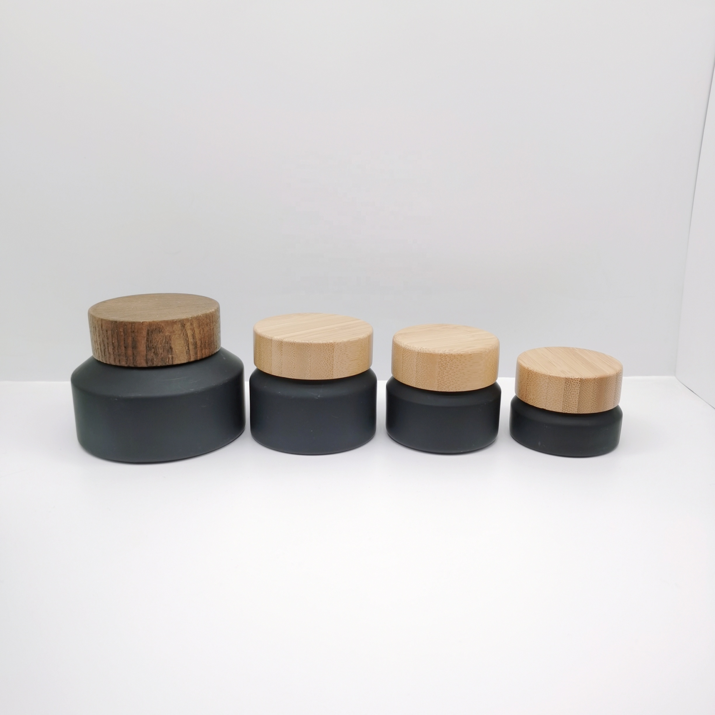 Factory production cosmetic glass bottles packaging slant shoulder matte black glass bottle and jar with bamboo lid series