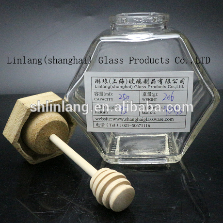 Honey glass jar with wooden lid and spoon