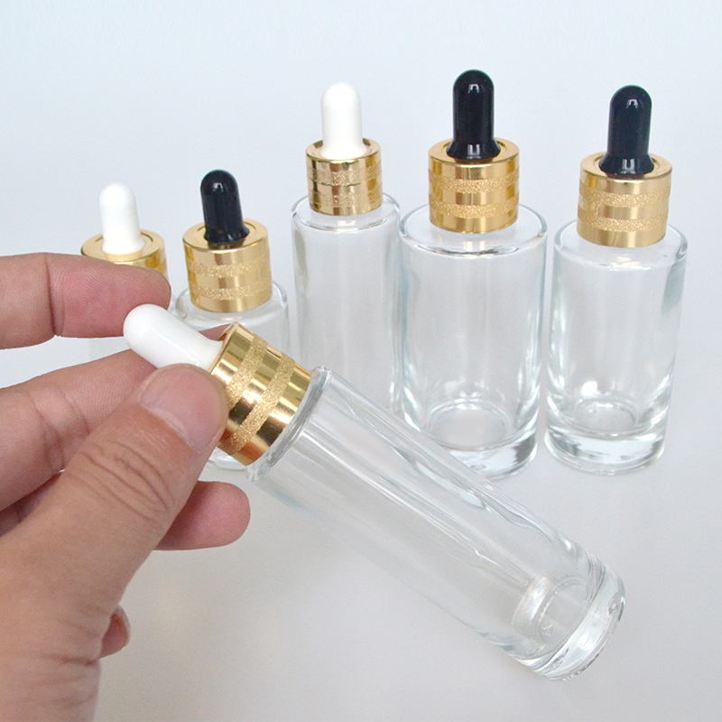 Hot sale luxury 30ml 50ml 60ml 100ml clear flat shoulder cosmetic beauty essential oil glass dropper bottle with gold cap