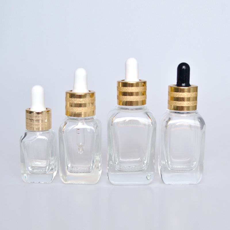 Hot sale luxury 30ml 50ml 60ml 100ml clear flat shoulder cosmetic beauty essential oil glass dropper bottle with gold cap