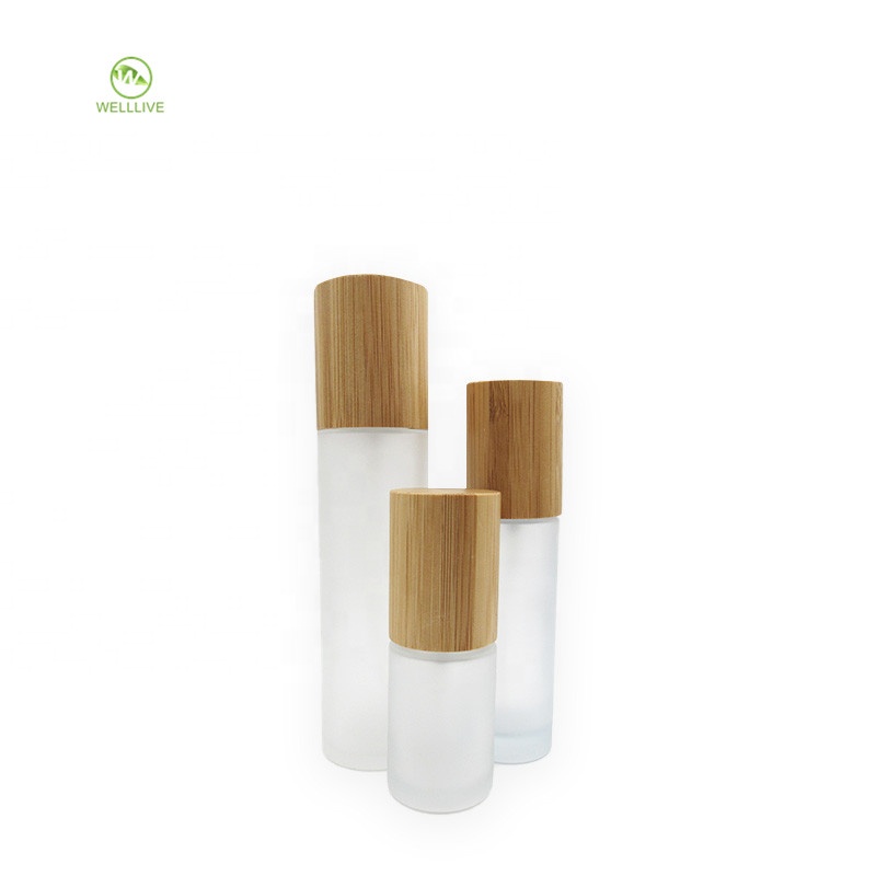 Luxury cylinder cosmetic container clear frosted glass pump bottle 50ml 60ml 2 oz with bamboo wooden sprayer lid