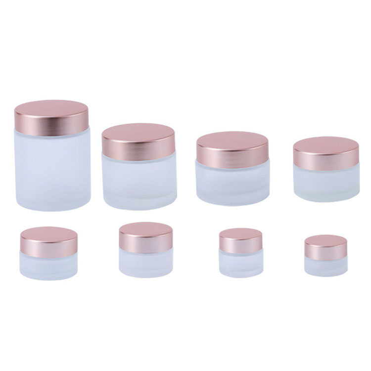 Luxury wholesale 5g 10g 20g 30g 50g 100g 200g amber cosmetic jar empty frosted glass jars with relief logo rose gold lid