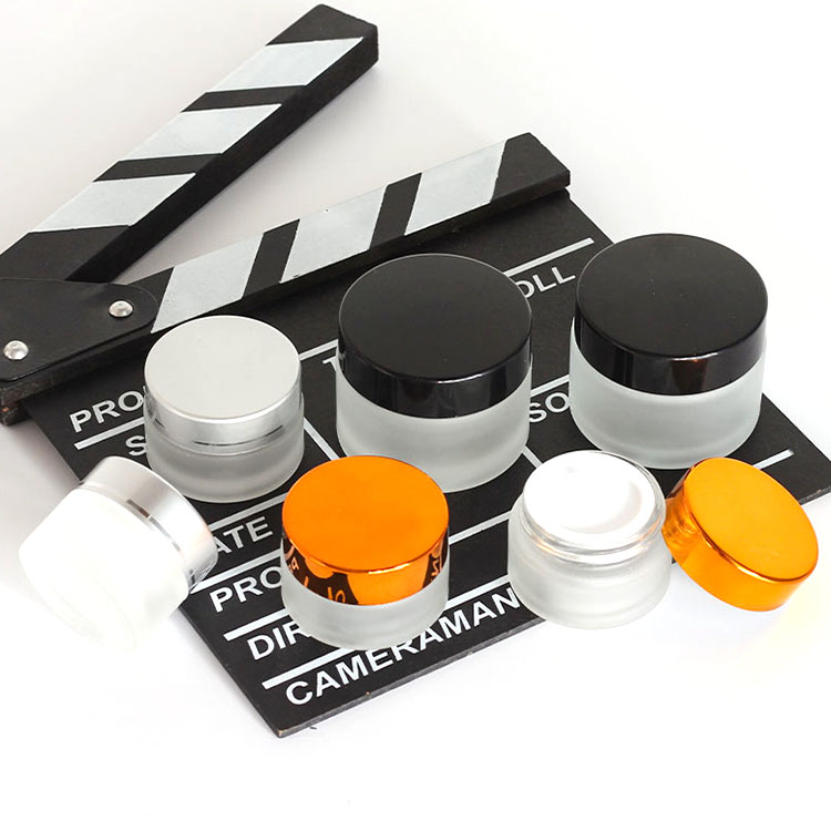 Luxury wholesale 5g 10g 20g 30g 50g 100g 200g amber cosmetic jar empty frosted glass jars with relief logo rose gold lid