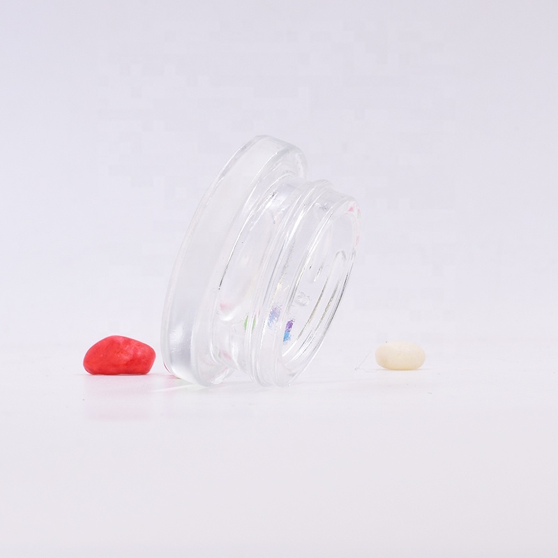 New 9 ml clear round small straight side eye cream cosmetic packing glass jar with black plastic child proof lid.