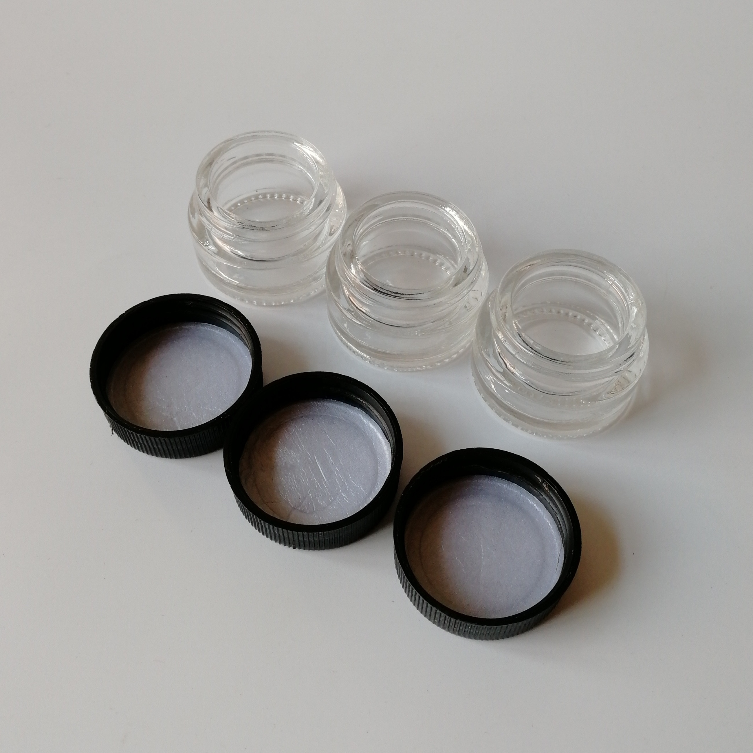 Popular Clear Glass Mini 3ml 5ml 7ml Skin Care Lotion Eye Cream Glass Jars with Black Smooth Child Resistant Lid