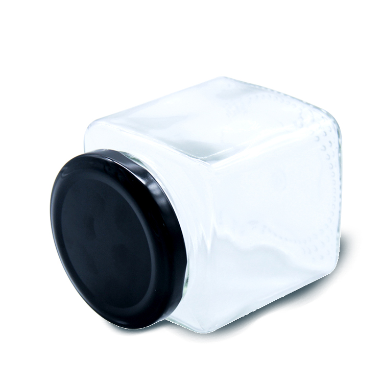 Square glass honey jar with black metal lid.