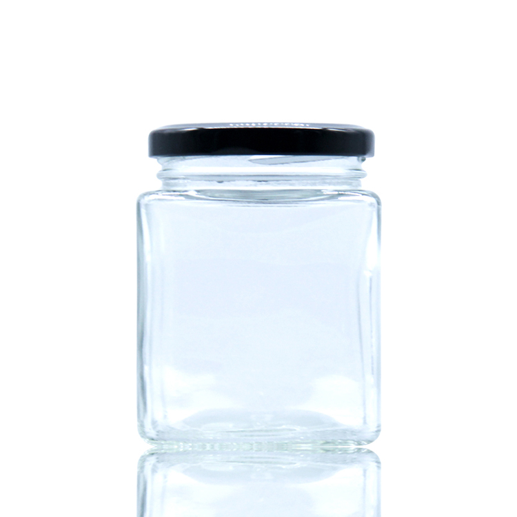 Square glass honey jar with black metal lid.