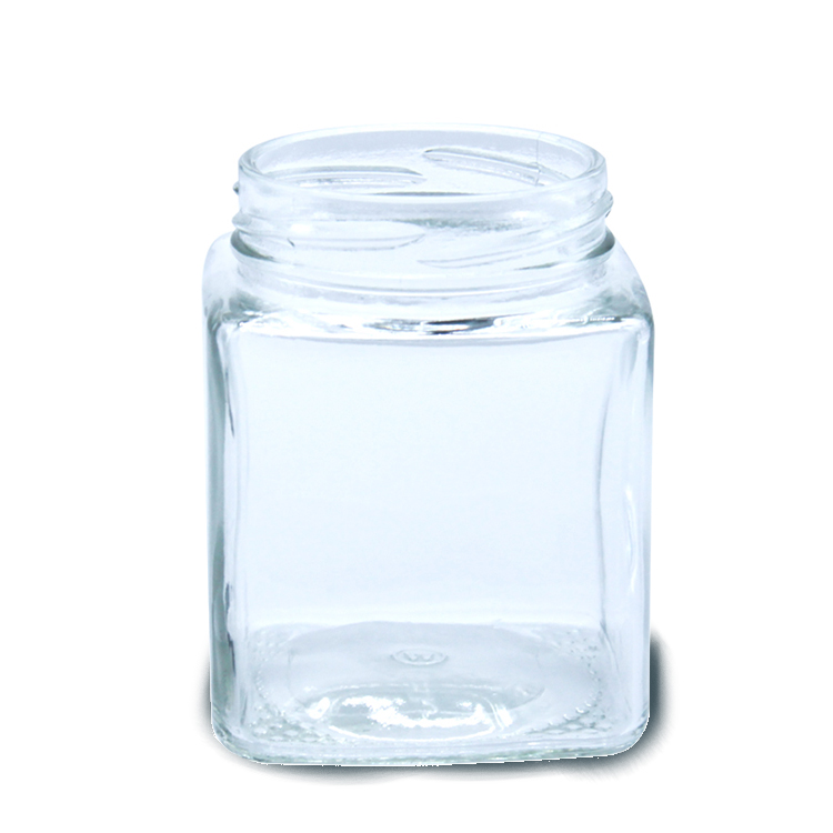 Square glass honey jar with black metal lid.