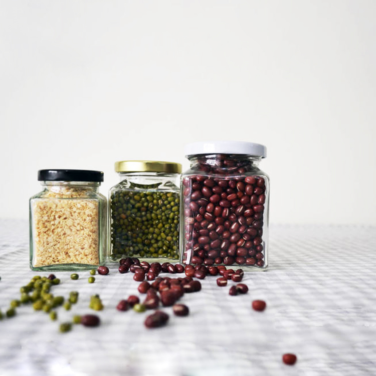 Square glass honey jar with black metal lid.