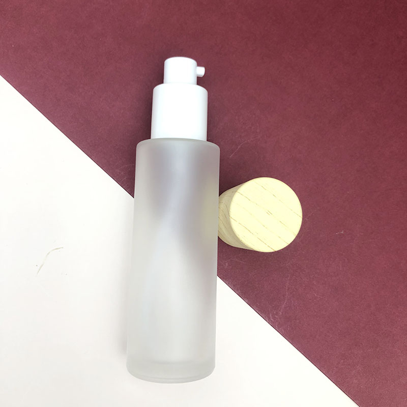 Wholesale cosmetic packaging round clear empty serum lotion foundation glass bottle with pump