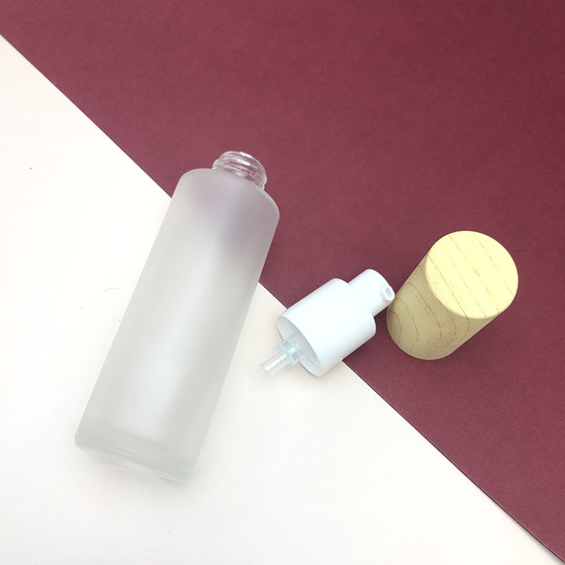 Wholesale cosmetic packaging round clear empty serum lotion foundation glass bottle with pump