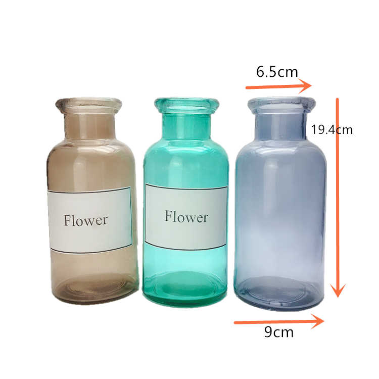 clear colored round glass flower bottle, vase
