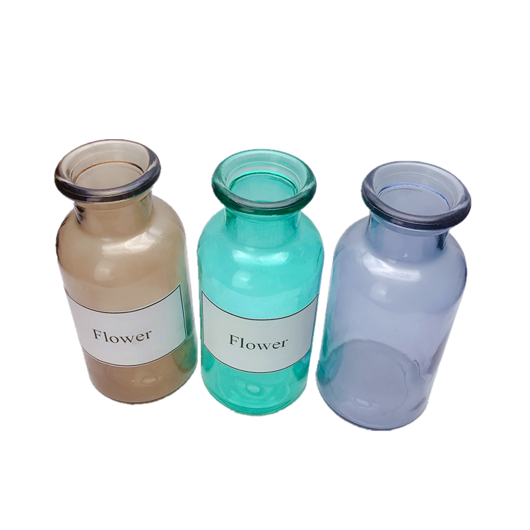 clear colored round glass flower bottle, vase
