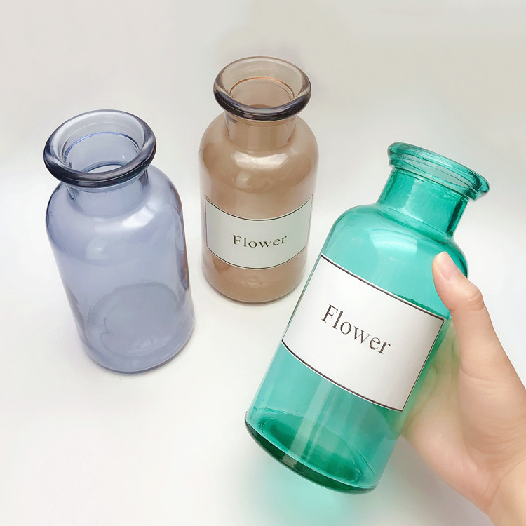 clear colored round glass flower bottle, vase